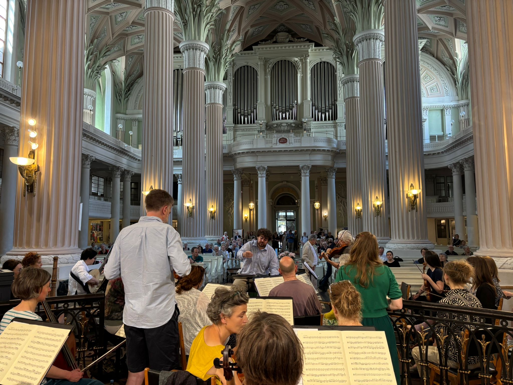 Finan Jones rehearsing the Constellation Choir and Orchestra, Nikolaikirche, Leipzig. Credit: Iris Korfker.
